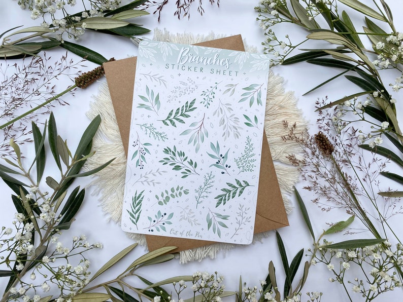 Op de afbeelding: Een stickerblad met een witte achtergrond en verschillende groene en grijze takken en bladeren. Het blad is getiteld "Branches Sticker Sheet" en heeft de tekst "Out of the Pen" onderaan.