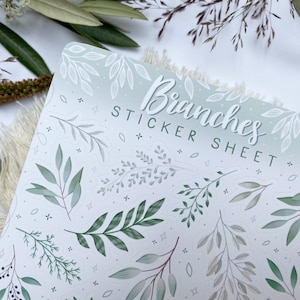 Op de afbeelding: Een stickerblad met een witte achtergrond en een groene en grijze gradi&euml;nt. Het blad bevat verschillende illustraties van takken en bladeren. De tekst "Branches Sticker Sheet" is in het zwart bovenaan het blad gedrukt.