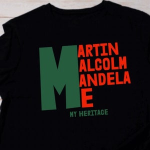 May include: Black t-shirt with a green "M" and red text that reads "MARTIN ALCOLM ANDELA E" and "MY HERITAGE".