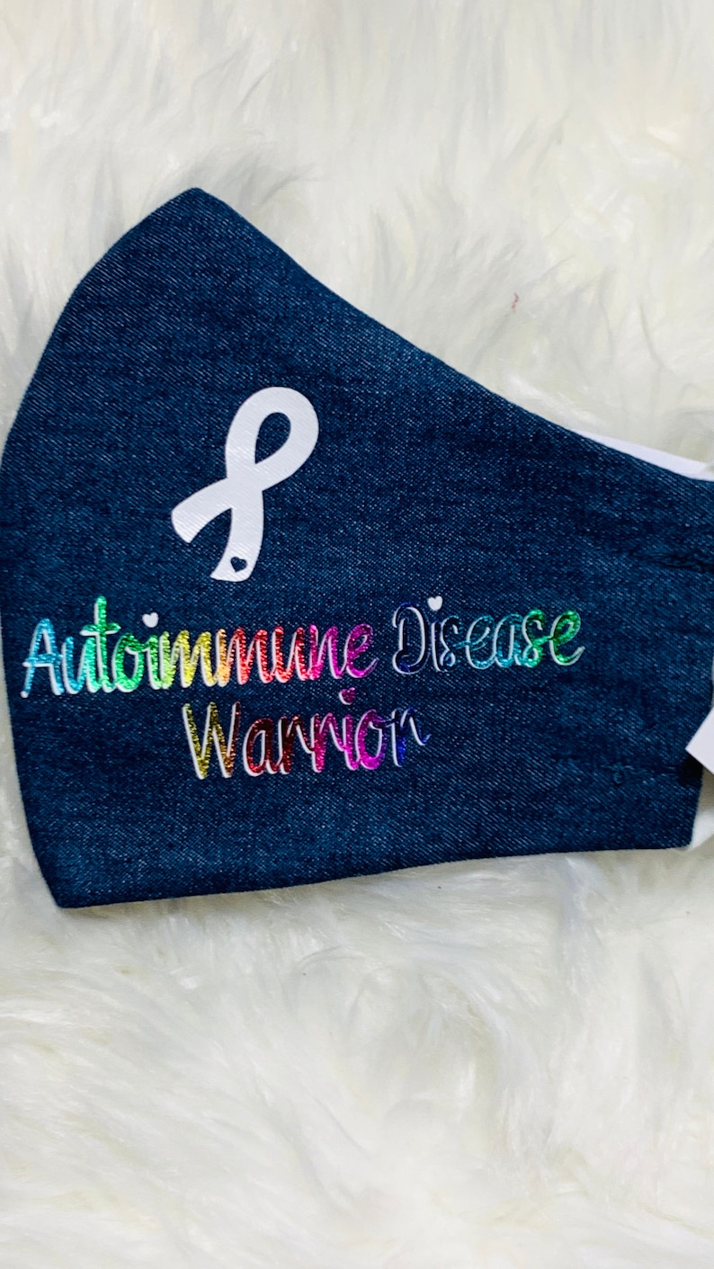 May include: A blue denim face mask with a white ribbon and the text "Autoimmune Disease Warrior" in rainbow glitter.