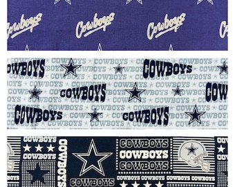 May include: Three fabric swatches with a repeating pattern of the word "Cowboys", stars, and a football helmet. The color scheme is primarily navy blue, white, and gray. The top swatch has a navy blue background with white stars and the word "Cowboys".