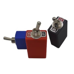 May include: Three toggle switches in red, blue, and black. Each switch has a silver lever and a rectangular base. The red and black switches have "ON" and "OFF" labels. The blue switch is partially visible.