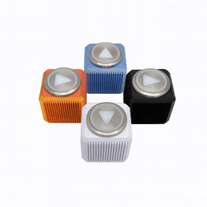 May include: Four square buttons in orange, blue, black, and white. Each has a textured surface and a silver circular top with a white triangle. The buttons are designed with a modern aesthetic.