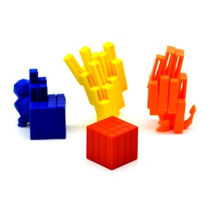 May include: Four colorful 3D printed geometric shapes: a blue lion, a yellow hand, an orange abstract shape, and a red cube.