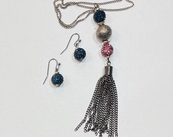 Conjunto de colar com pingente de contas e brincos com acabamento em tom de chumbo.
