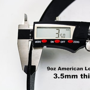 May include: Close-up of a black leather strap being measured with a digital caliper. The caliper reads 3.50 mm. The text below reads "9oz American Leather 3.5mm thick".