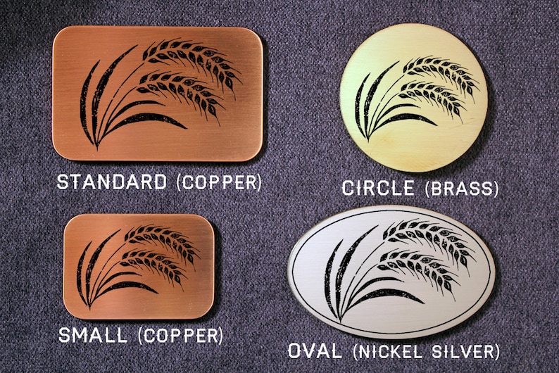 May include: Four metal plaques with a black wheat design. The plaques are in different shapes and sizes: standard, circle, small, and oval. The plaques are made of copper, brass, and nickel silver.