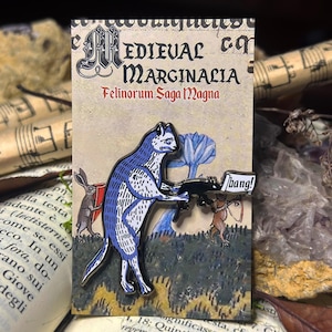 May include: A blue cat holding a gun with a speech bubble that says "bang!" The cat is part of a medieval style illustration with a background of green and brown.