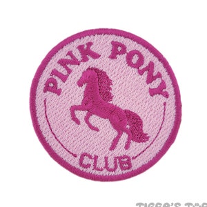 以下が含まれることがあります： ピンクと白の刺繍パッチで、ピンクの馬と「Pink Pony Club」の文字が書かれています。
