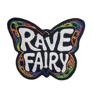 May include: A black butterfly-shaped embroidered patch with the words "RAVE FAIRY" in white. The patch is decorated with rainbow-colored thread around the edges and details, creating a vibrant design.