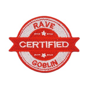 Puede incluir: Parche bordado en rojo y blanco. El parche circular presenta las palabras "RAVE CERTIFIED GOBLIN" en blanco. Una pancarta roja en el centro dice "CERTIFIED". Dos estrellas están situadas encima y debajo de la pancarta.