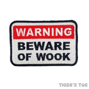 May include: White warning sign with black border and red text that says "WARNING" and black text that says "BEWARE OF WOOOK"