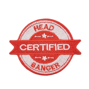 May include: A round, embroidered patch with a red and white design. The patch features the words "HEAD CERTIFIED BANGER" in white lettering. The patch has a red banner across the center and star accents.