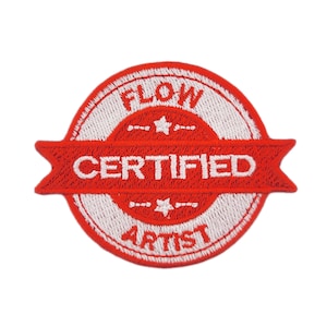 May include: Embroidered patch with a red and white design. The patch is circular with a red banner across the centre that reads "CERTIFIED". Above and below the banner are the words "FLOW" and "ARTIST" in red. The patch has a white border.