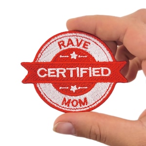 May include: A red and white embroidered patch with the words "RAVE CERTIFIED MOM". The patch is circular with a banner across the centre. The text is in white, and the border is white.