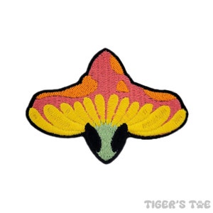 May include: A pink and yellow embroidered mushroom patch with a green stem and black outline.