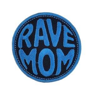 May include: A circular patch featuring the text "RAVE MOM" in blue embroidery on a black base. The patch is edged with a stitched border, suitable for application to garments or bags.
