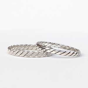 May include: Two silver rings with a braided design.