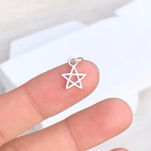 Puede incluir: Un amuleto de plata en forma de estrella de cinco puntas.