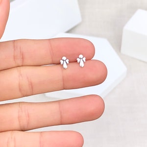 May include: A pair of silver angel wing stud earrings. The earrings are small and delicate, and they would make a great gift for someone special.