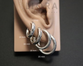 May include: Four silver hoop earrings of varying sizes displayed on an ear model. The hoops are labeled with their respective diameters of 14 mm, 16 mm, 18 mm, and 20 mm. The text LIORA JEWELRY HOUSE is visible at the top of the display model.
