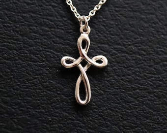 May include: A silver chain necklace with a delicate, twisted cross pendant.