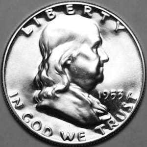 May include: A silver coin featuring a profile of a man, with the word "LIBERTY" at the top and "IN GOD WE TRUST" at the bottom. The year "1953" is visible. The coin is a Franklin half dollar.
