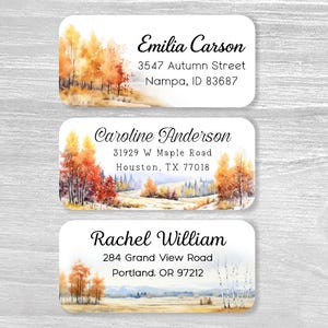 May include: Three rectangular address labels featuring watercolor illustrations of autumn landscapes with orange and yellow trees. Each label displays a unique name and address: Emilia Carson, Caroline Anderson, and Rachel William with their respective locations.
