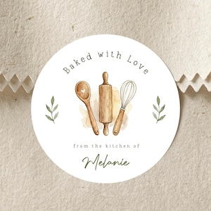 May include: A circular white sticker featuring a watercolor illustration of a wooden spoon, a rolling pin, and a whisk. The text reads Baked with Love from the kitchen of Melanie. Two small green leaf sprigs flank the kitchen tools on each side.