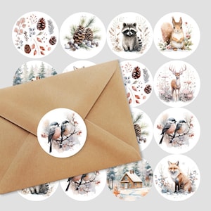May include: Set of 12 round stickers featuring watercolour illustrations of woodland animals and winter scenes. The stickers feature a raccoon, squirrel, deer, birds, pine cones, and a cabin in the woods.