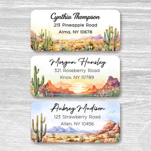 May include: Three address labels with desert landscape illustrations. Each label features a name and address, with the names Cynthia Thompson, Morgan Hansley, and Aubrey Madison. The labels have a watercolor style with cacti and mountains.