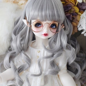 May include: A gray wig with long, loose curls and bangs. The wig is styled on a doll with blue eyes and a white dress.