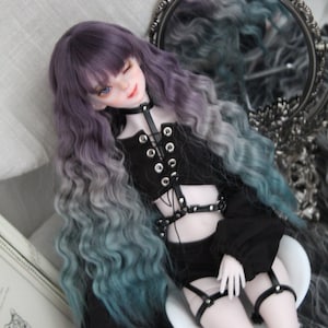 May include: A doll with long, wavy, purple and teal hair wearing a black, lace-up crop top and a black skirt with a silver buckle. The doll is sitting on a white chair.