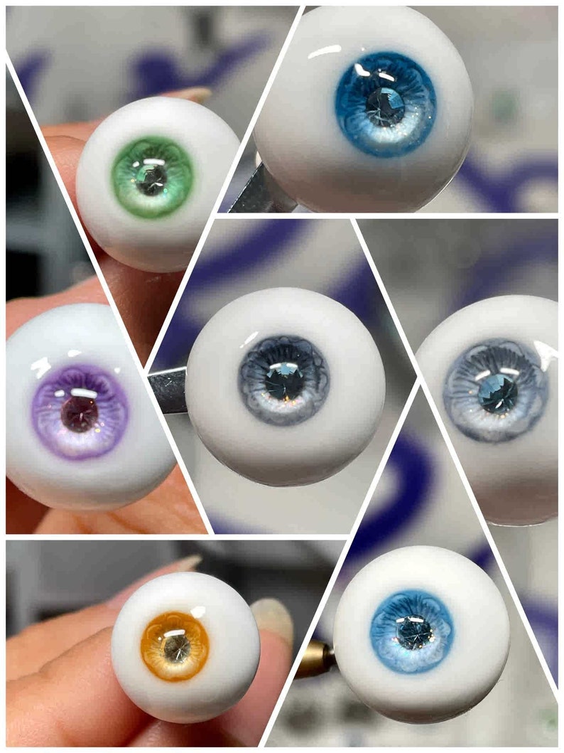 Op de afbeelding: Een verzameling van zes verschillende gekleurde glazen ogen met een witte basis en een donkerblauwe iris. De ogen zijn gerangschikt in een raster.