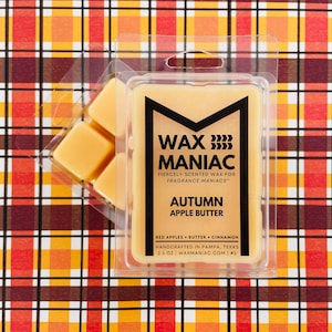 May include: A wax melt in a clear plastic container with a black and gold label. The label reads "Wax Maniac" and "Autumn Apple Butter". The scent description is "Red Apples, Butter, Cinnamon". The wax melt is handcrafted in Pampa, Texas and is 2.5 oz.