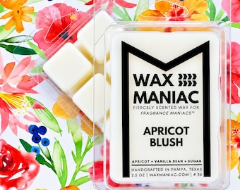 May include: A clear plastic clamshell container holding six white wax melt cubes. The label features the text WAX MANIAC, FIERCELY SCENTED WAX FOR FRAGRANCE MANIACS, APRICOT BLUSH, APRICOT + VANILLA BEAN + SUGAR, HANDCRAFTED IN PAMPA, TEXAS, 2.5 OZ.