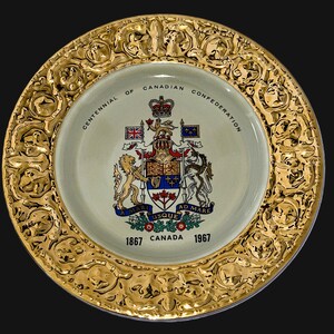 May include: A decorative plate with a gold-colored, ornate rim. The center features a crest with a crown, flags, and the text "Centennial of Canadian Confederation." The plate also includes the dates "1867 CANADA 1967."