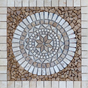 May include: A circular mosaic tile design with a starburst pattern in the center. The tile is made of small, irregular pieces of stone in shades of brown, beige, and white.