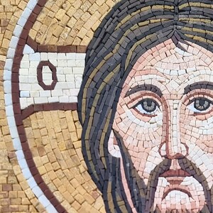 May include: A mosaic artwork depicting a religious figure with a halo. The portrait features a detailed face with a beard, dark hair, and light skin tones. The mosaic is composed of small, square tiles in various colors.