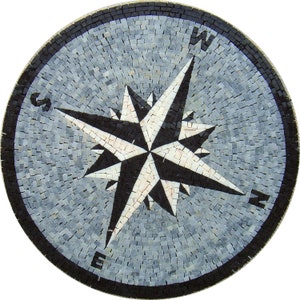 May include: Circular mosaic compass rose design. The compass rose features a black and white starburst pattern with directional letters N, S, E, and W. The background is a mosaic of small grey tiles, and the outer border is black.
