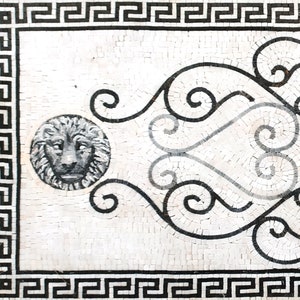 Puede incluir: Dise&ntilde;o de mosaico en blanco y negro con una cabeza de le&oacute;n en un c&iacute;rculo y un patr&oacute;n de desplazamiento decorativo. El dise&ntilde;o est&aacute; enmarcado por un borde de clave griega en blanco y negro.