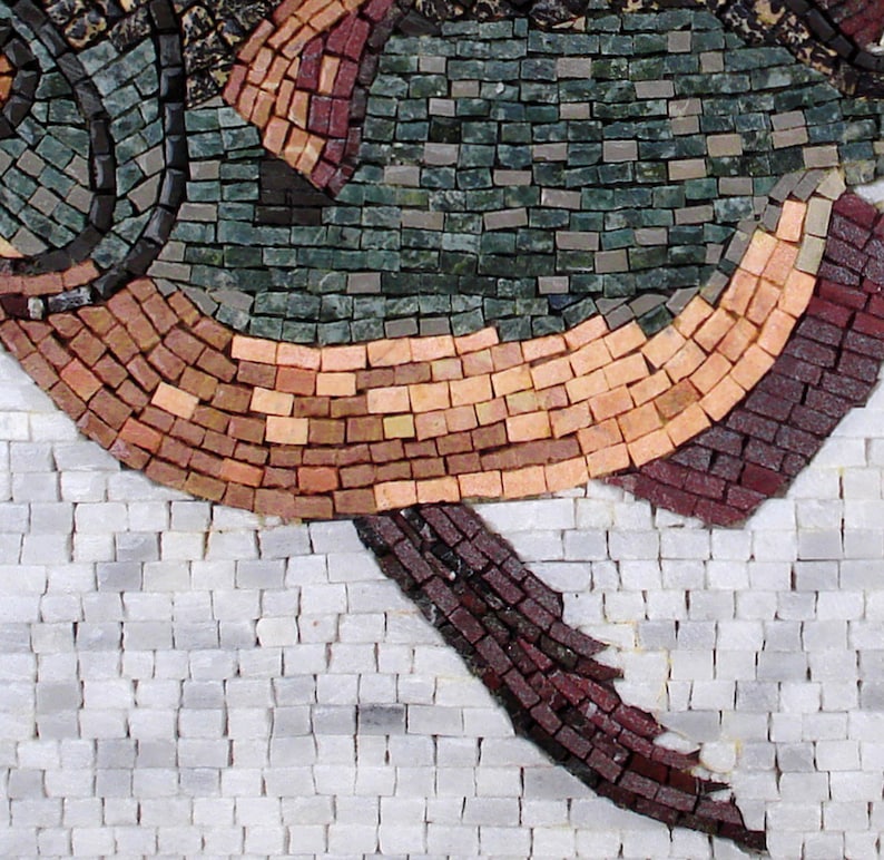 May include: Close-up of a mosaic artwork depicting a fish. The fish is composed of small, rectangular tiles in shades of green, brown, and red. The background is white, creating a striking contrast. The mosaic style gives the artwork a textured appearance.