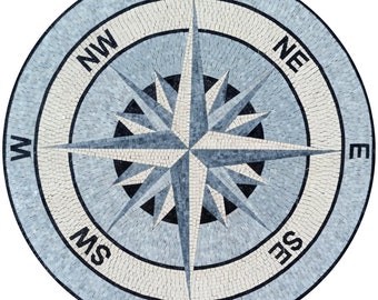 May include: A blue and white mosaic compass with a black star in the center. The compass points north, south, east, and west, with the cardinal directions labeled in black.