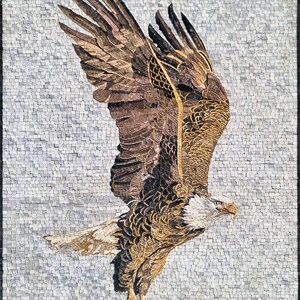 May include: A mosaic artwork depicting a bald eagle in flight. The eagle is made of small, colorful tiles, creating a textured and detailed image. The eagle's wings are spread wide, and its head is turned to the side, as if it is looking for prey. The background is a light gray, which contrasts with the eagle's brown and white feathers.