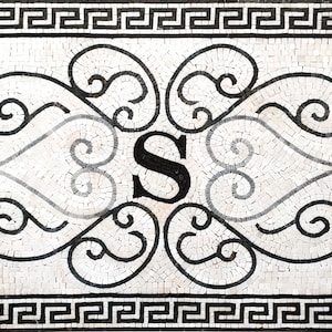 Puede incluir: Azulejo de mosaico blanco y negro con un borde de clave griega y un dise&ntilde;o decorativo que presenta una letra estilizada "S" y dos cabezas de le&oacute;n.