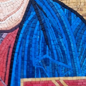 May include: Close-up of a mosaic artwork featuring a figure with a blue garment. The mosaic is composed of small, colorful tiles, with blue, red, tan, and black being the dominant colors. The artwork has a detailed, textured appearance.