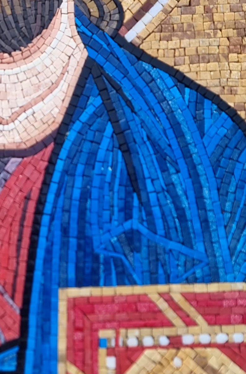 May include: Close-up of a mosaic artwork featuring a figure with a blue garment. The mosaic is composed of small, colorful tiles, with blue, red, tan, and black being the dominant colors. The artwork has a detailed, textured appearance.
