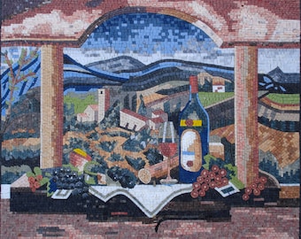 Puede incluir: Obra de arte en mosaico que representa una naturaleza muerta con una botella de vino, dos copas y uvas. El fondo muestra un paisaje con colinas, edificios y un cielo azul. La obra está enmarcada por un arco de piedra.