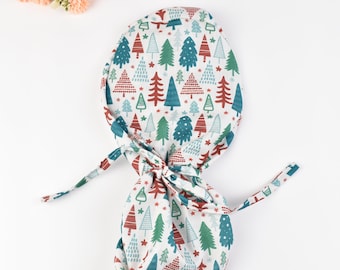 May include: White scrub hat with a Christmas tree pattern in red, green, and white. The hat has a tie on the back.