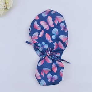 May include: A blue surgical scrub hat with a pink and blue butterfly print.